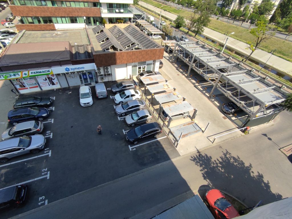 Cum se fac afaceri cu locuri de parcare în spatele sediului PNL din Podu Roș. Primul parklift din oraș ruginește nefolosit, parcarea publică de alături e scoasă la închiriat dar la altă adresă