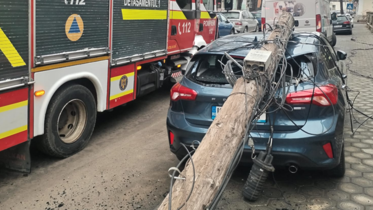 Mașină zdrobită de un stâlp de comunicații prăbușit peste ea, în Copou